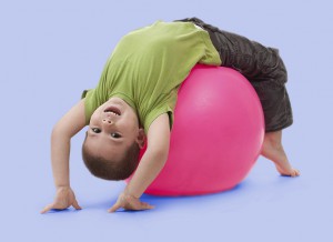 four-year-old boy having upside-down fun on an exercise ball