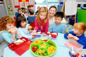 A group of pre-Kindergarten children enjoy a healthy, fruit-based morning snack.