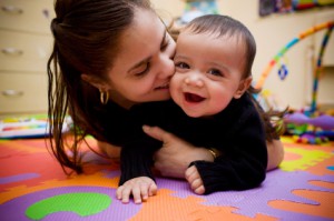 young HIspanic/Latina mother snuggles her happy 10-month-old son