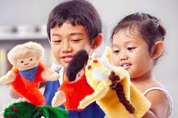 two shy, Asian pre-schoolers use puppets to tell stories